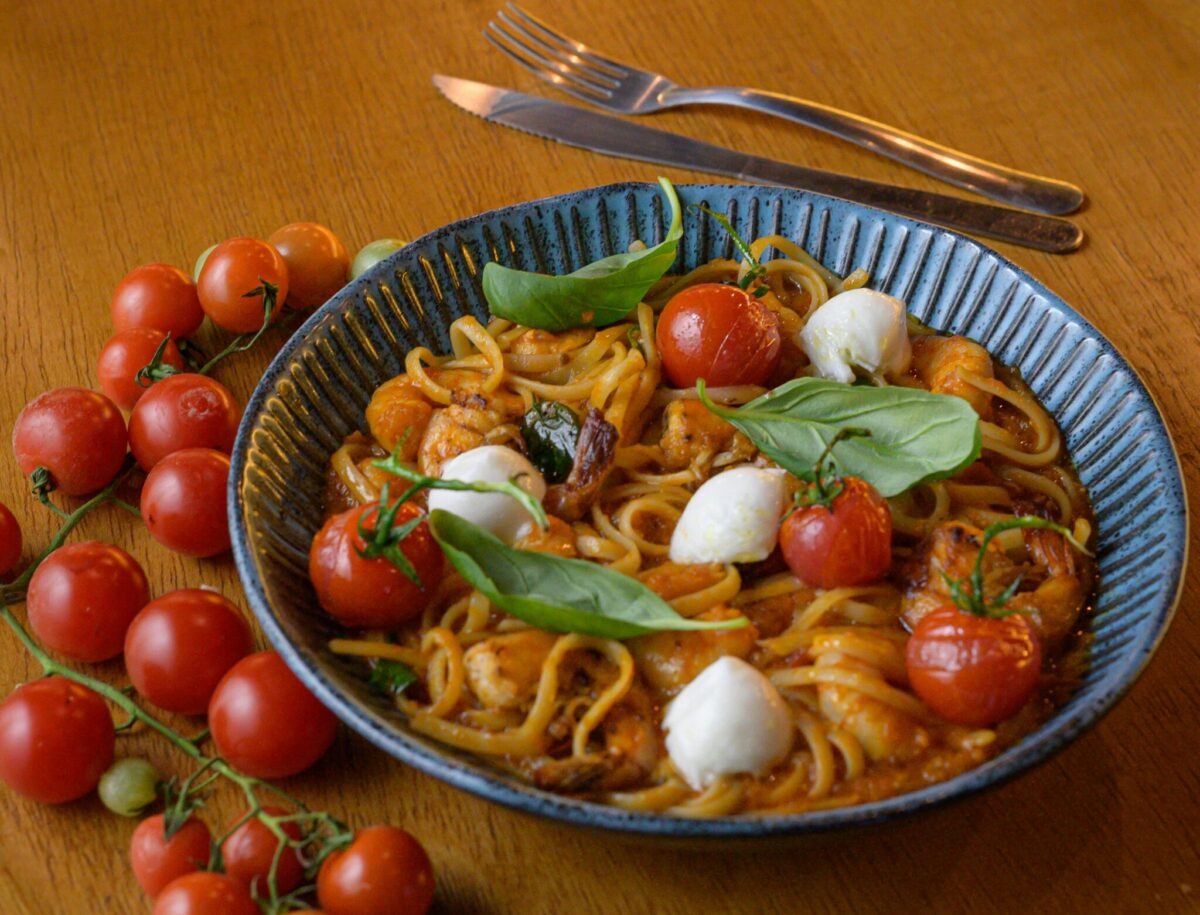 A colourful bowl of the easy family pasta recipe featuring cream cheese, tomatoes, and basil, ideal for cooking with kids