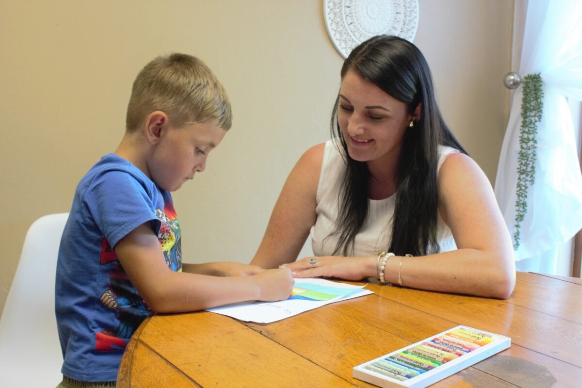 A parent and child work closely together on a puzzle, representing the supportive journey of homeschooling a child with autism South Africa.